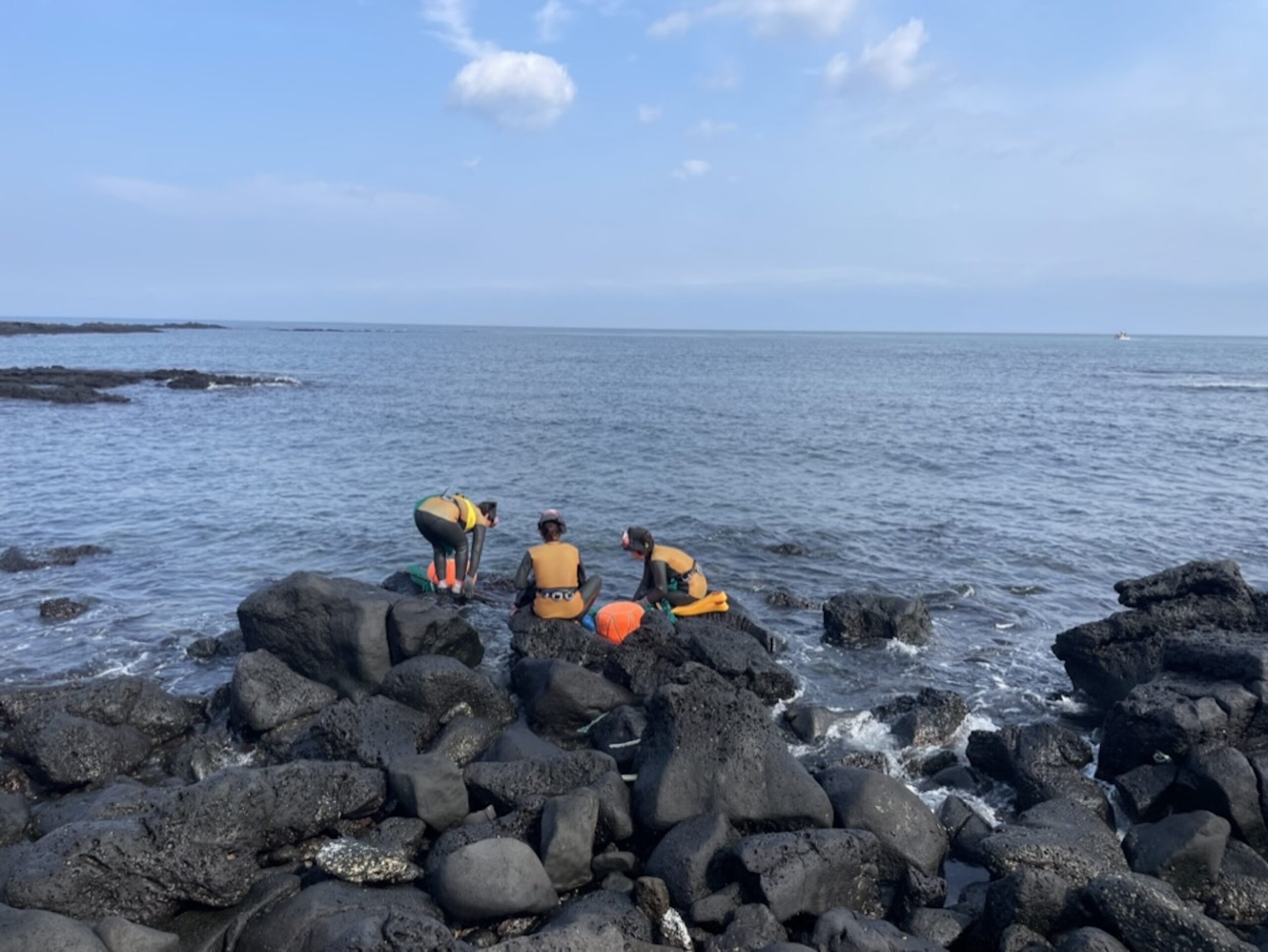 Group of female divers in Korea at the ocean's edge.